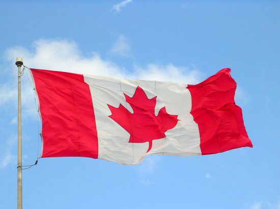 Mum's the word for Canada's eavesdropping agency as a canadian flag flies in the wind against a blue sky.