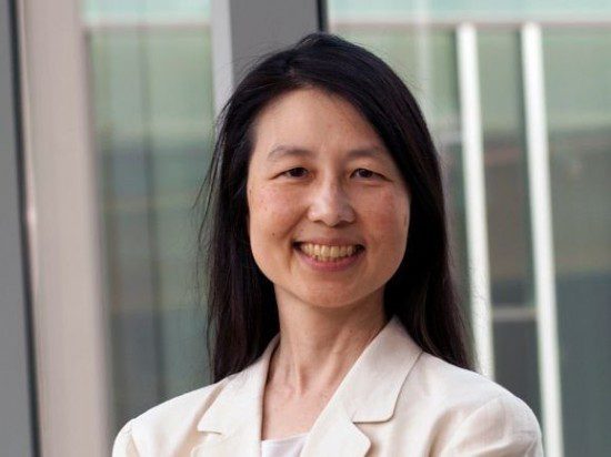 a woman in a white blazer standing in front of a window, symbolizing the game-changing influence of tech companies and enterprise hires.